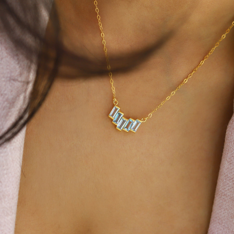 A modern style necklace with a baguette-shaped swiss blue topaz pendant.