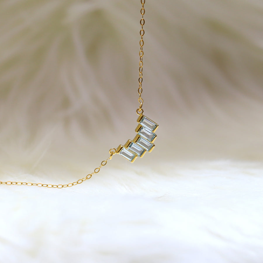 A modern style necklace with a baguette-shaped swiss blue topaz pendant.